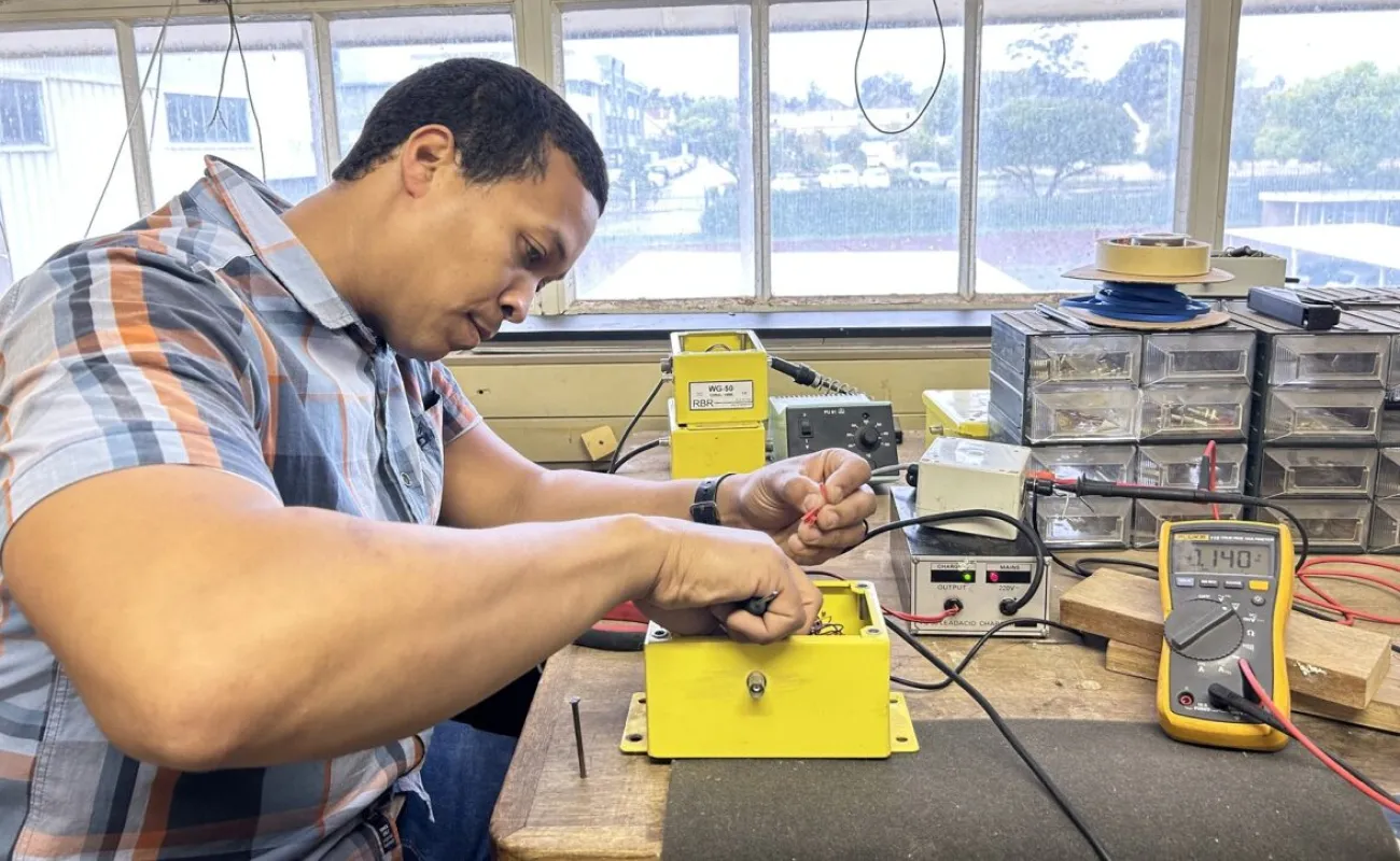 Hand holding a container with yellowish liquid