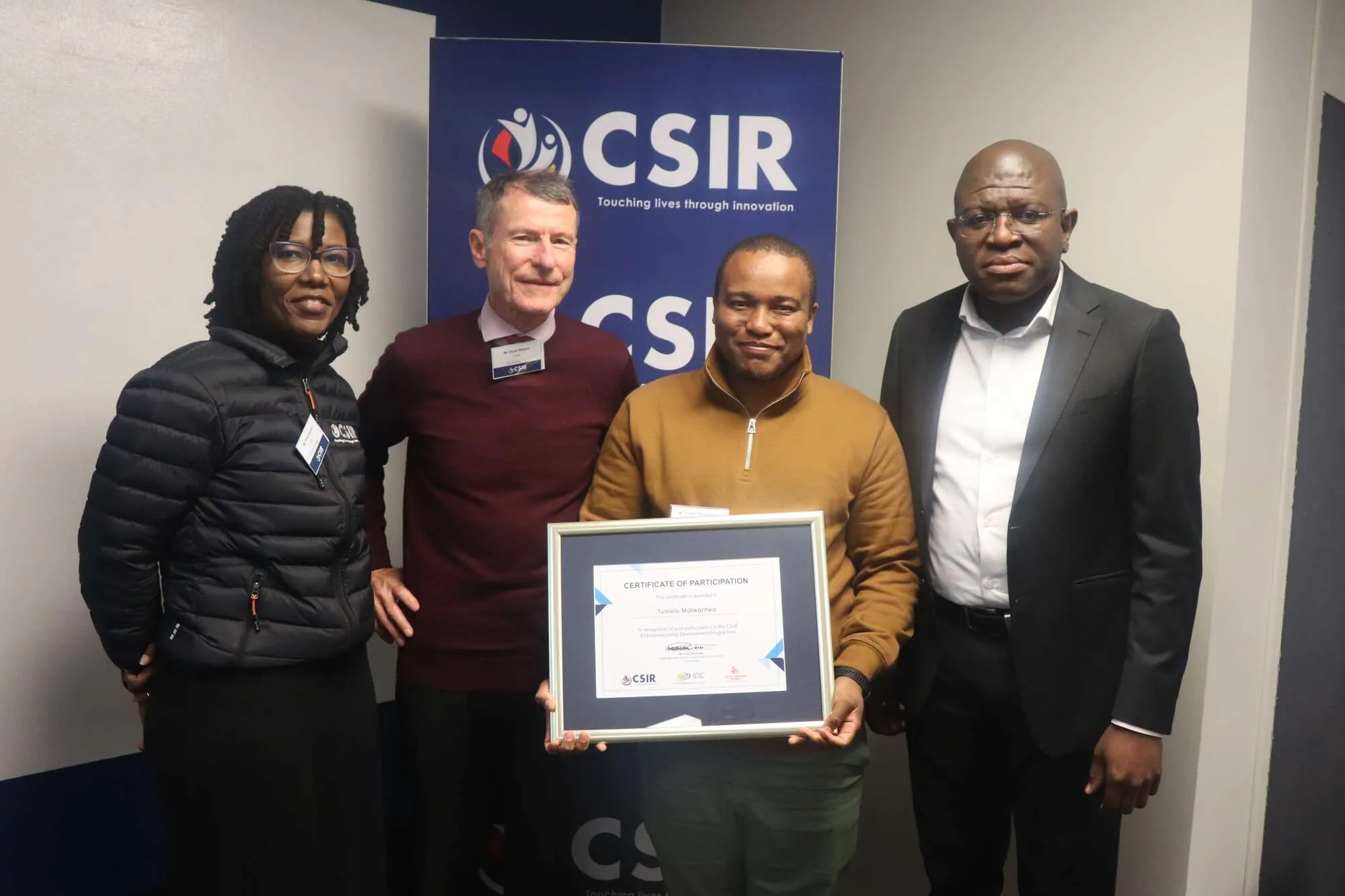 Four people smiling for a camera